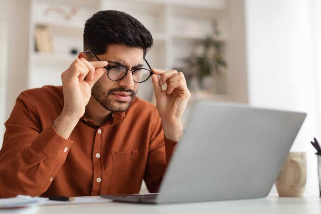 A man with presbyopia struggles to see a computer screen